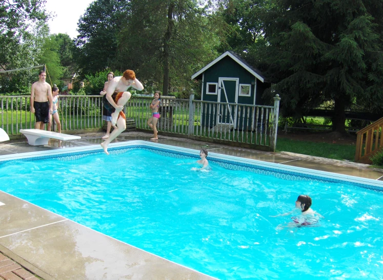 a boy and girl in the pool during summer