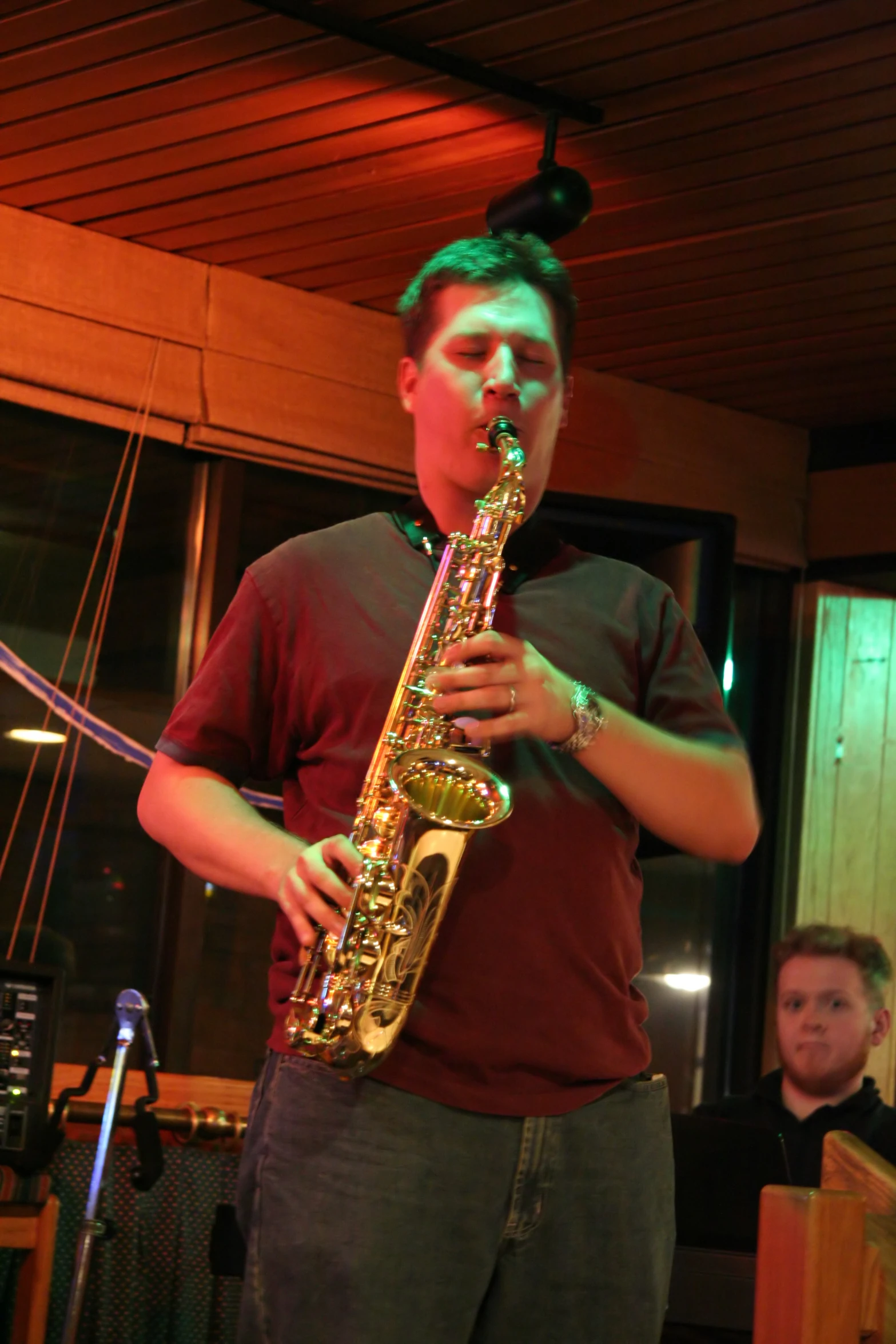a person standing and playing a saxophone with other people