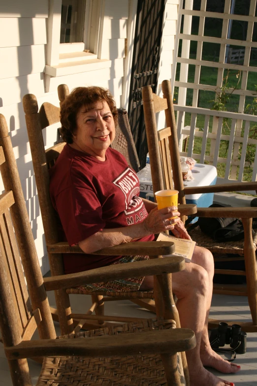 a woman with glasses sitting on an outside porch