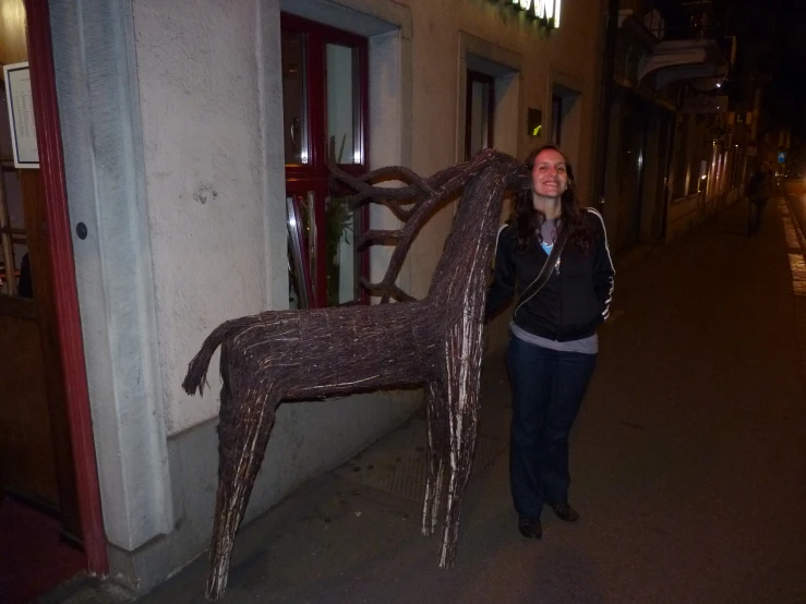 a woman standing beside a statue of a horse