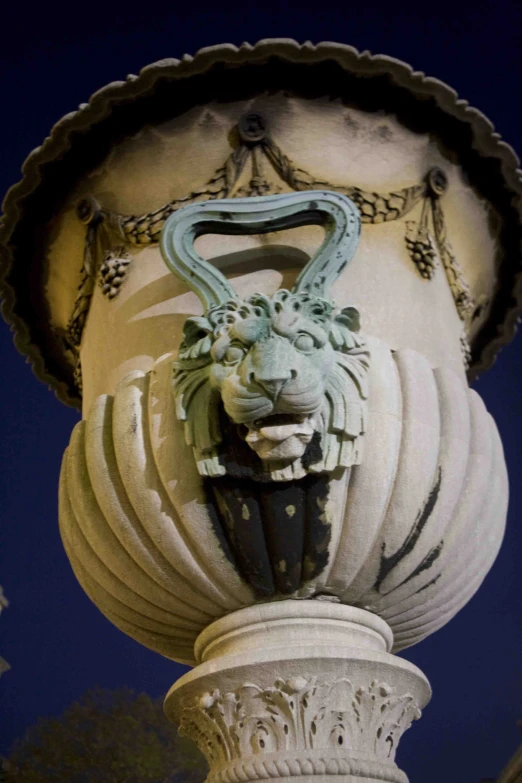 a stone fountain has an animal face on it