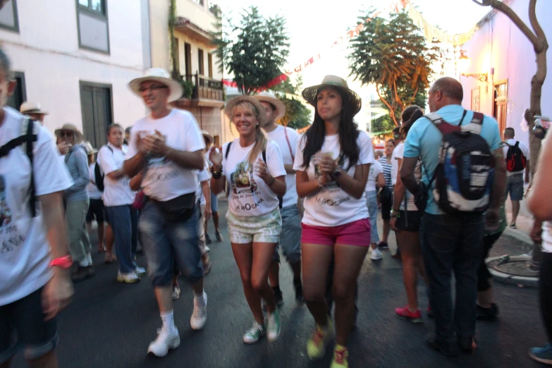 a group of people walking down a street next to each other