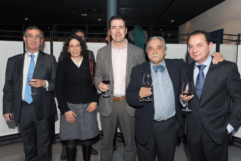 a group of people posing for a picture with wine glasses