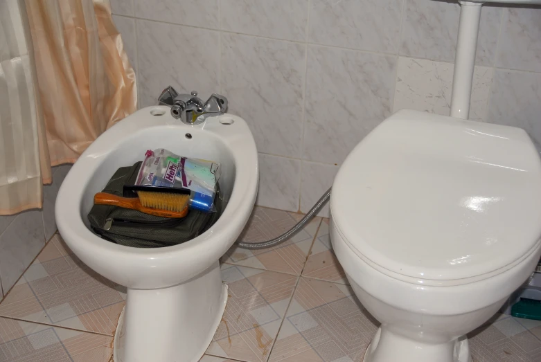 a white toilet sitting next to a white bathroom sink