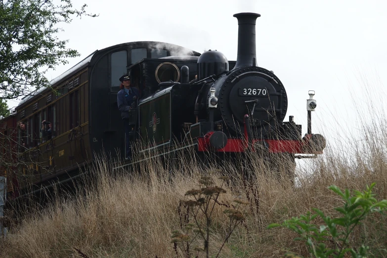 a train pulling into the station as it looks like a man is walking