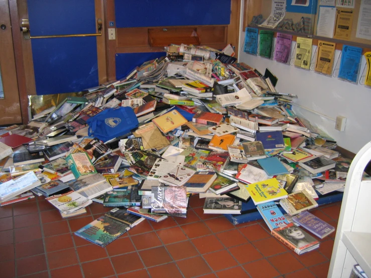 a pile of books and brochures sitting on top of a tiled floor