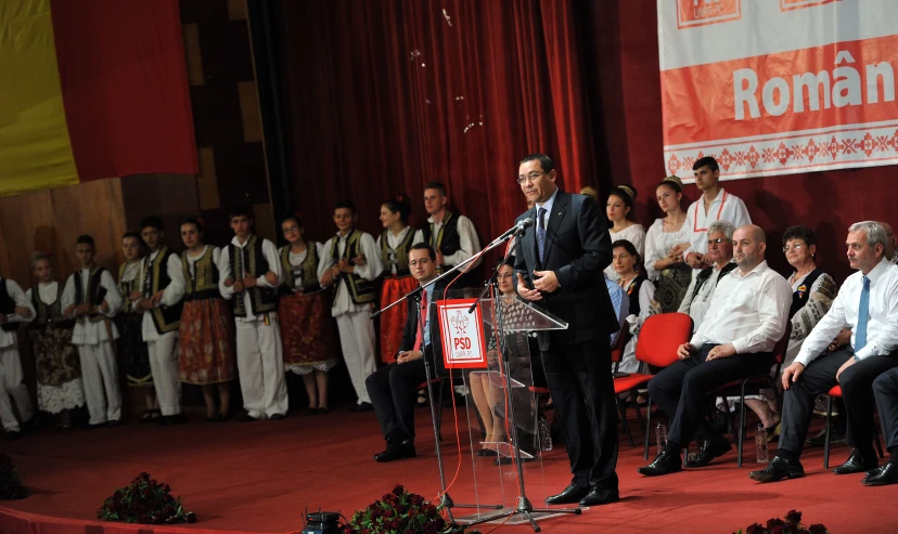 a speaker at an event speaking into microphones