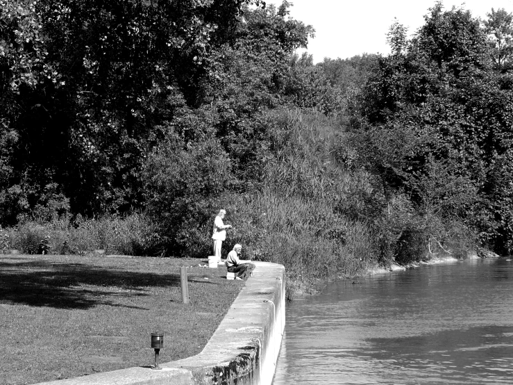 a person is sitting near the water on a dock