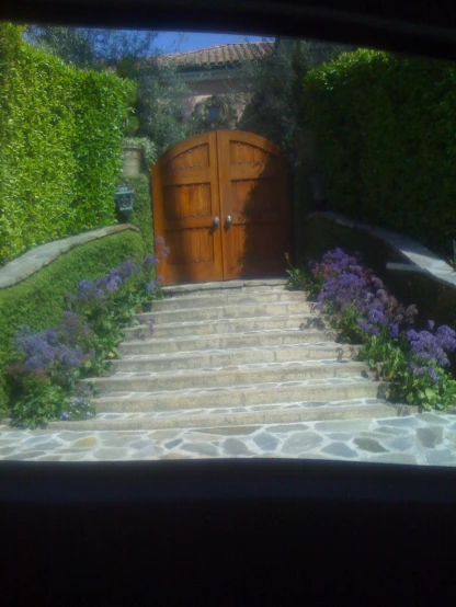 stairs lead to an open door near a beautiful garden