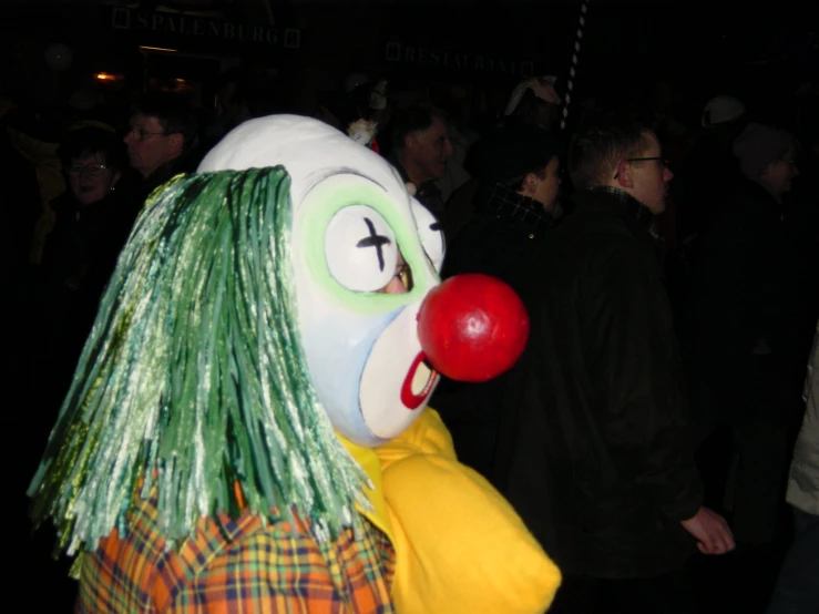 a clown standing next to a group of people