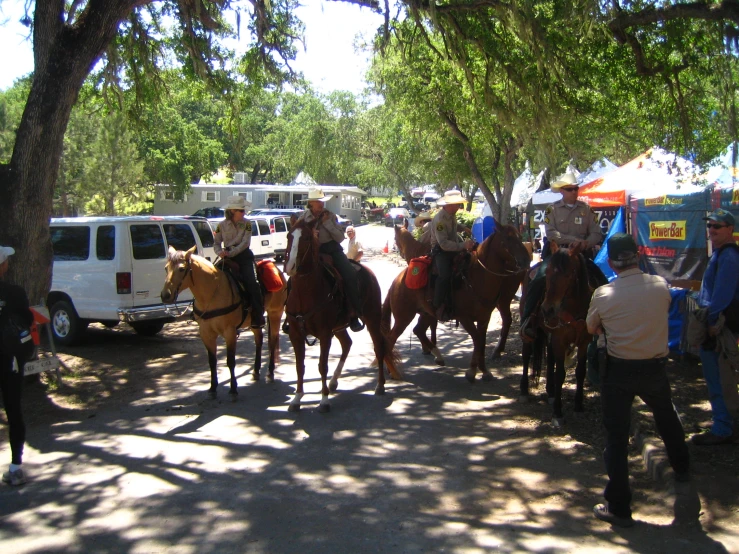 some people riding horses down a street in a city