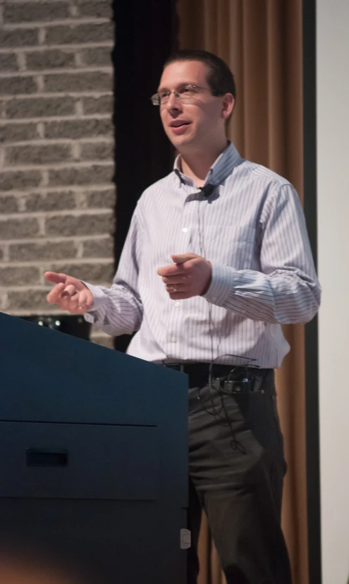 a man is standing up on the stage with his hands out