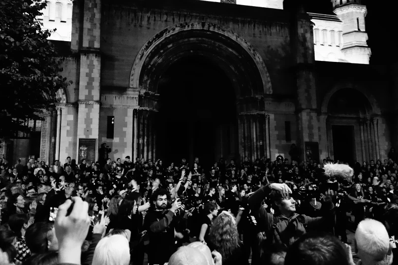 a crowd is in front of a cathedral looking into the doorway