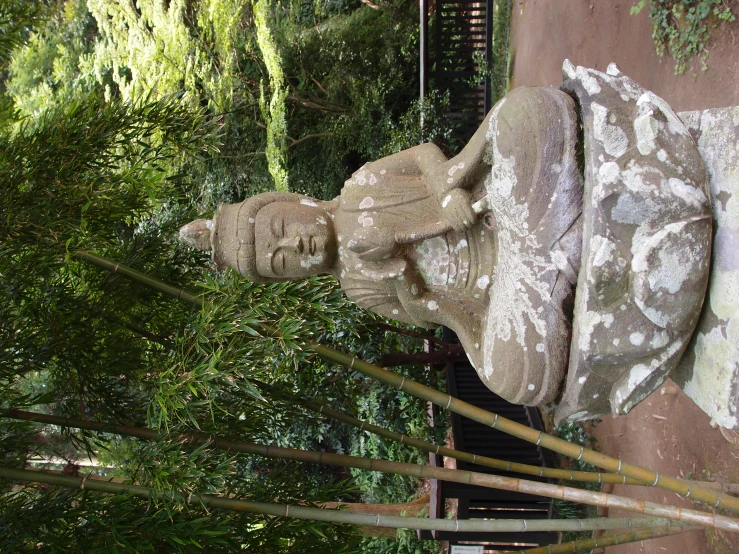 a statue is in a park with a stone walkway