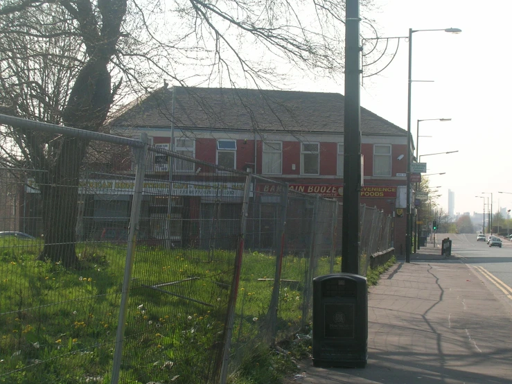 a street corner with a fence surrounding the building