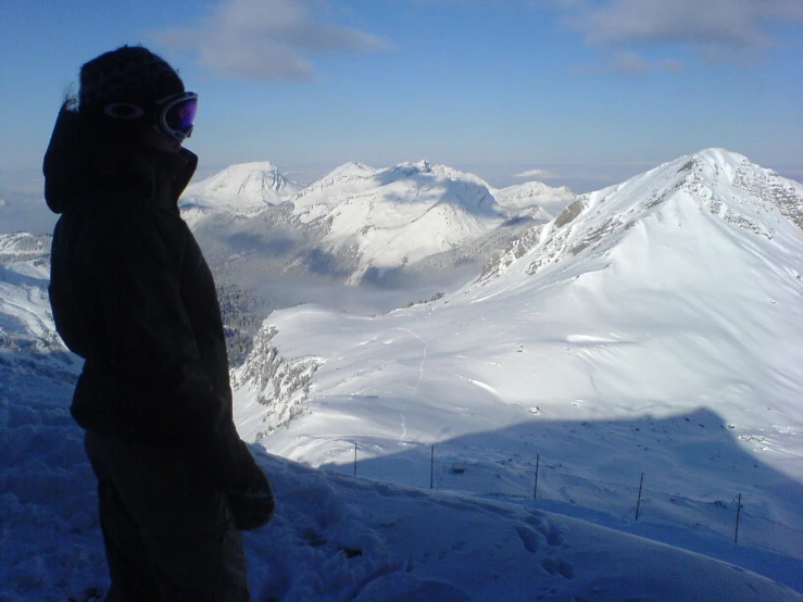 the man is standing on the ski slope and looking at the camera