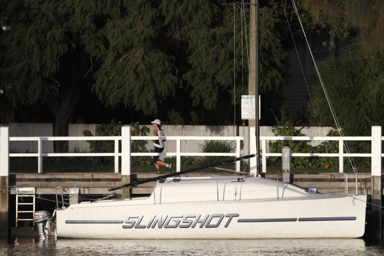 a man standing on the bow of a sailboat