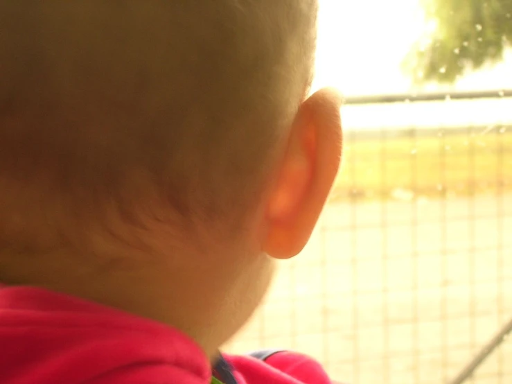 baby looking out the window at rain coming down