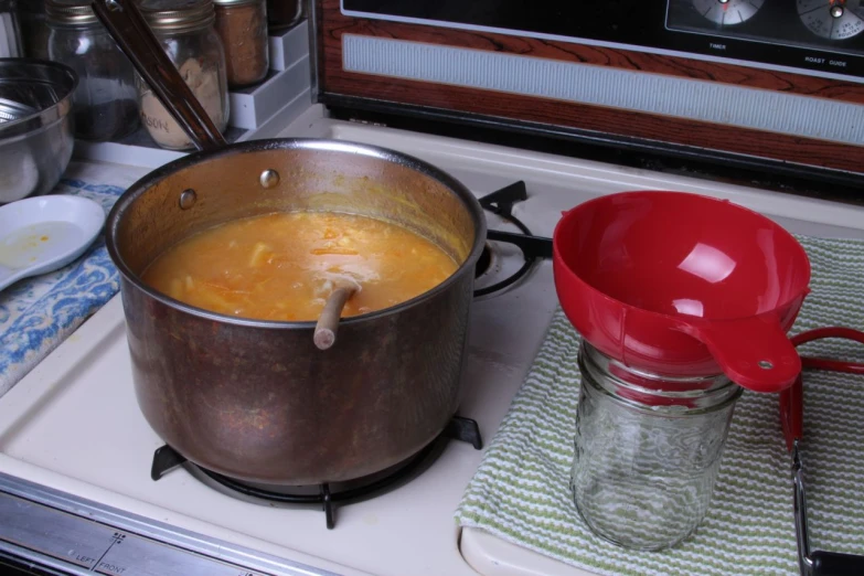 a pot of soup next to a small stove