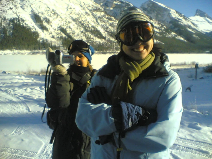 two young men in jackets, hats and goggles on a snowy surface