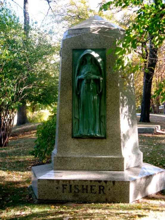 a memorial statue that has a figure of the virgin mary fisher