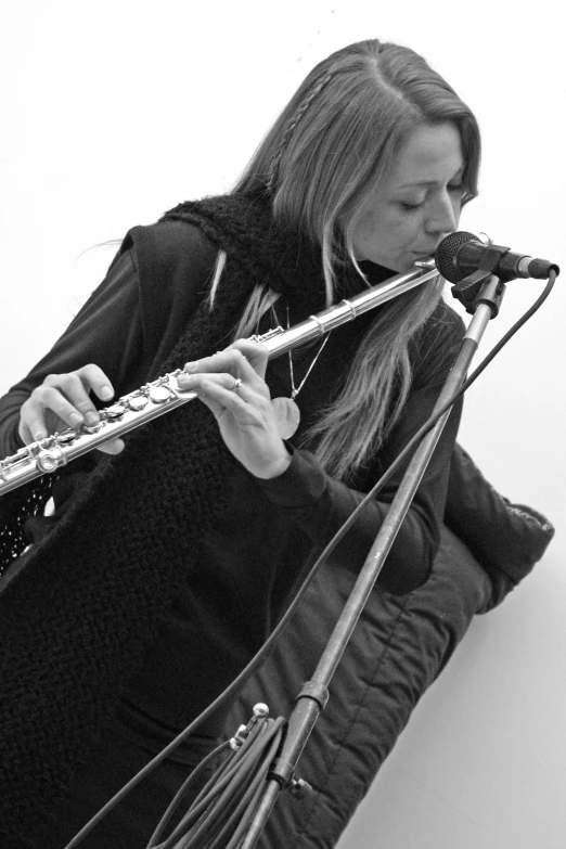 a woman with long hair playing a flute on stage