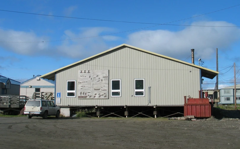 a house with lots of windows sitting next to some trucks