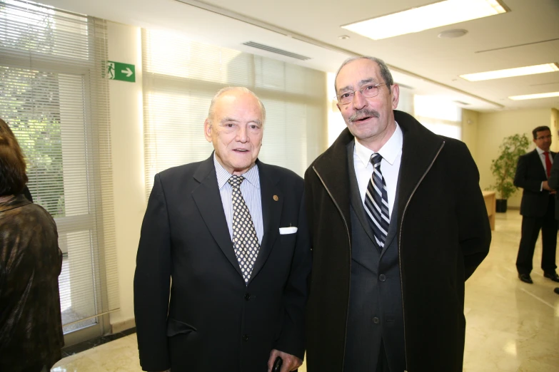 two men in business attire standing next to each other