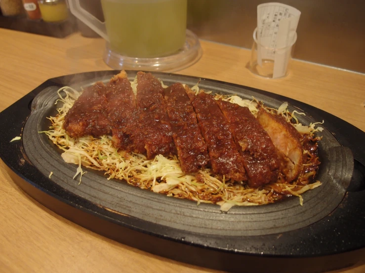 a plate of food with meat is on a tray with the meal