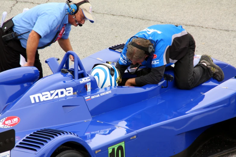 a man fixing the seat of a race car