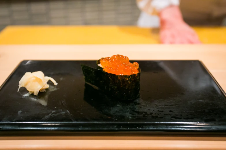 sushi at the restaurant served on a black plate