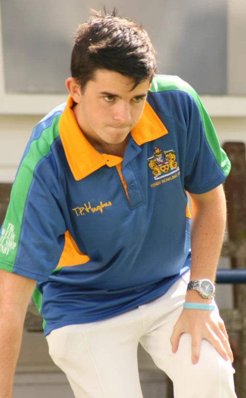 a boy wearing a blue, green and yellow polo shirt