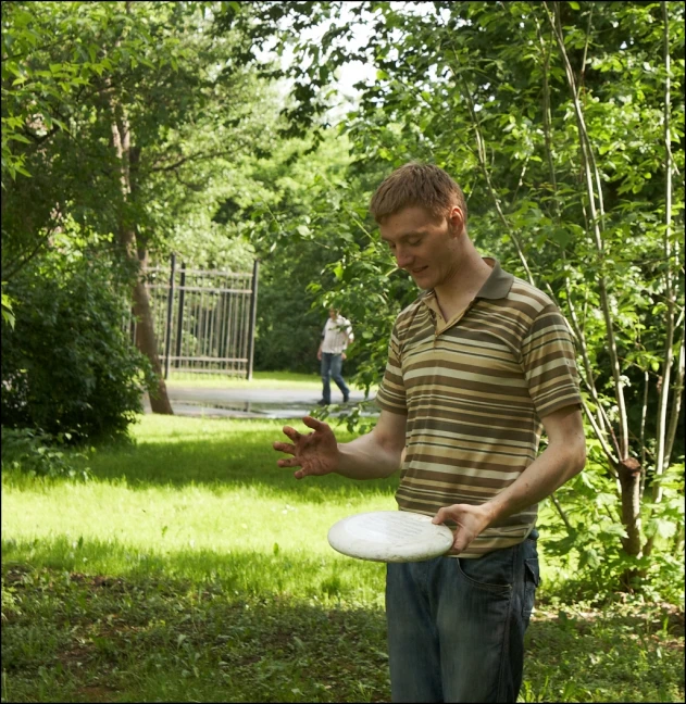 there is a man standing outside while holding a frisbee