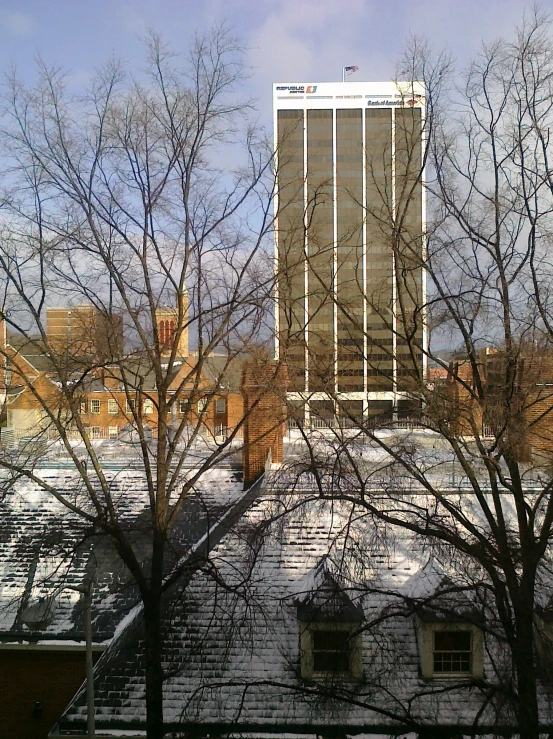 a building sits surrounded by snow covered trees and bare nches