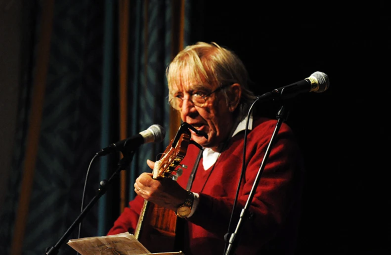 an old man is holding an instrument in his hands