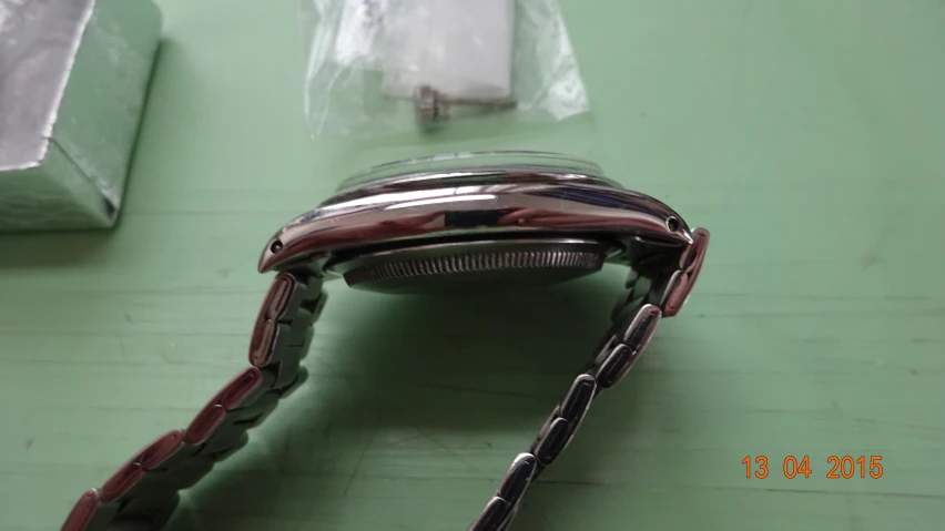 a smart watch sitting on a table with a piece of metal in front
