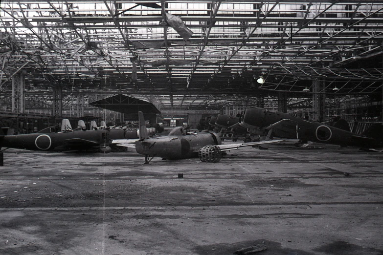 an old picture of several small airplanes inside of a hangar