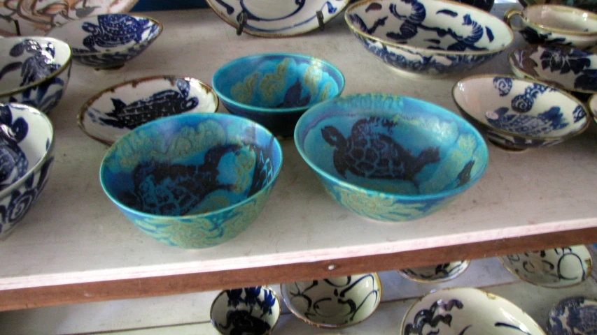 there are a bunch of bowls with blue decorations in it