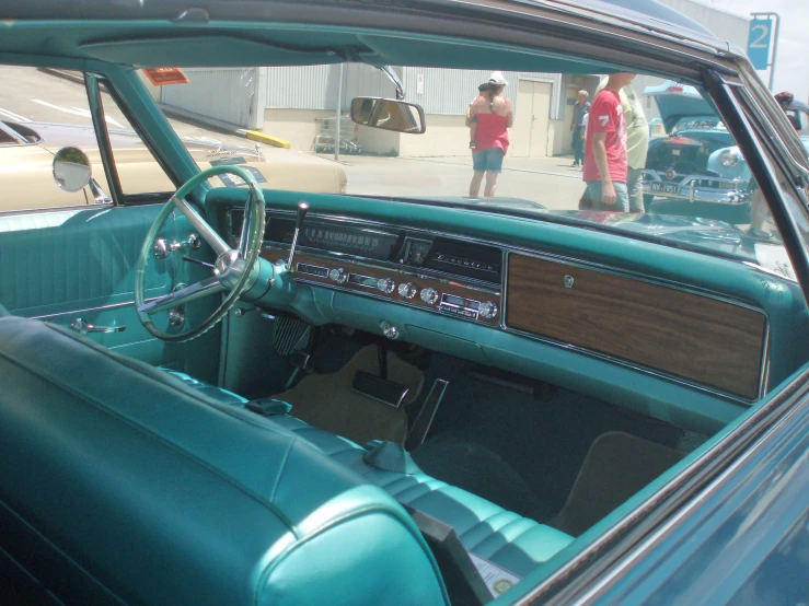 a man in red standing near an old car