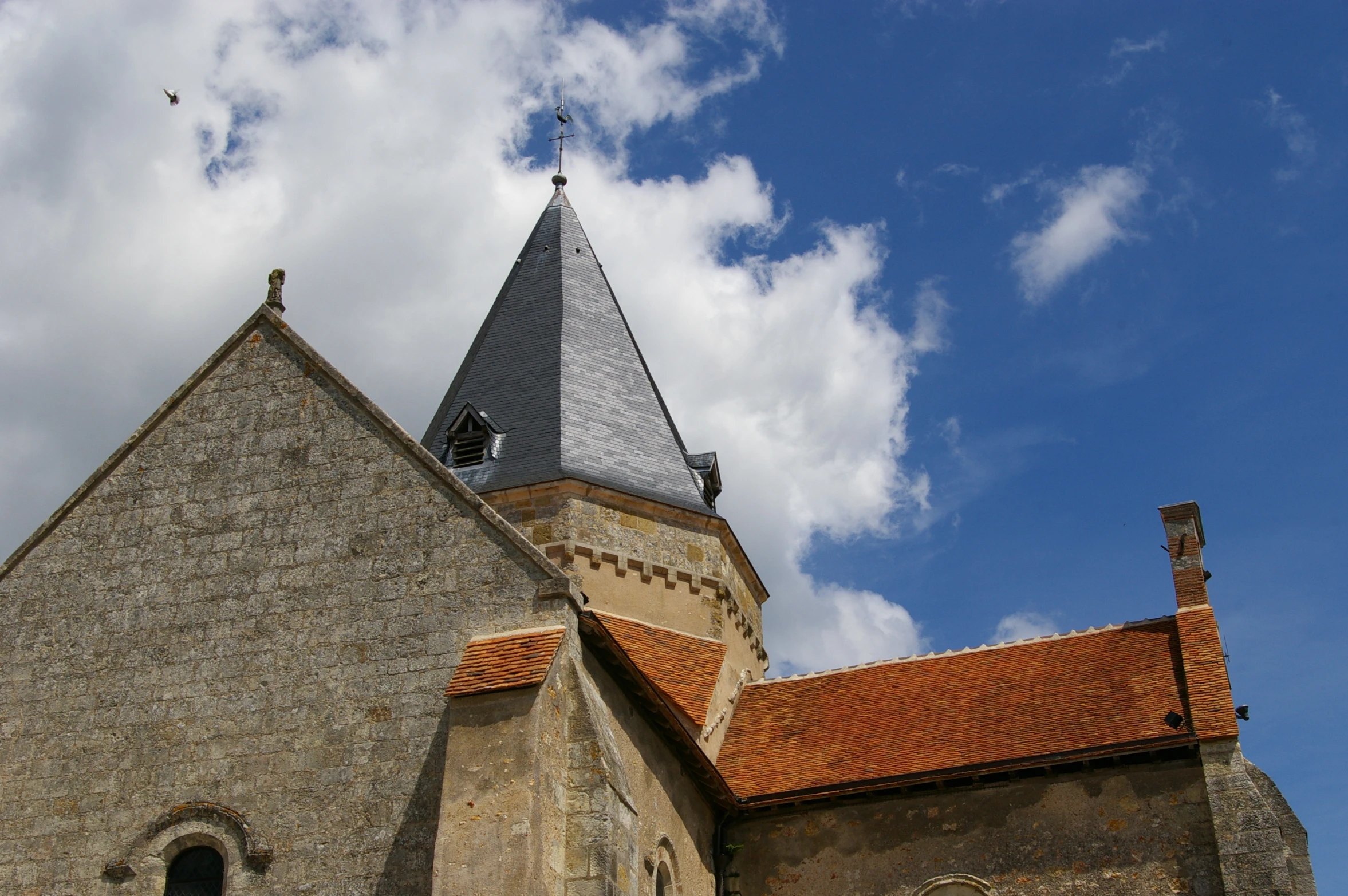a church with a tower and orange tile roof