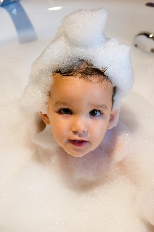 a baby playing with soap in the sink