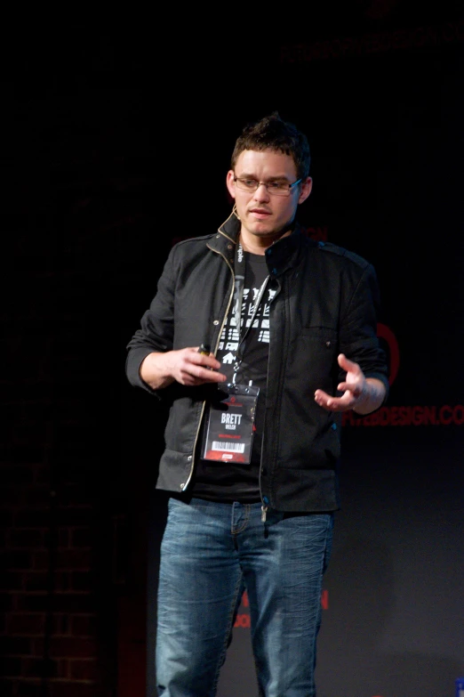 a man in glasses is standing and gesturing