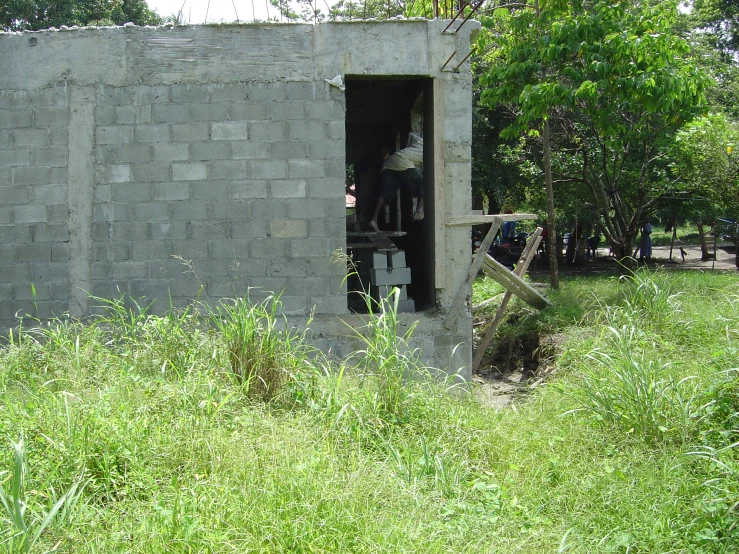 a gated in area with a brick wall and some green grass