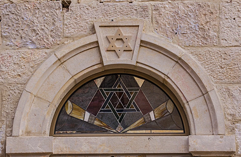 a po of the window of a church building with a masonic triangle