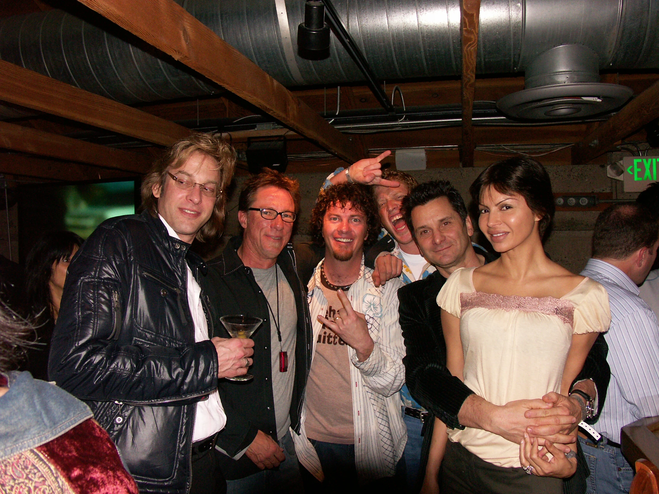 people in a bar with one man holding his arm up in front of him