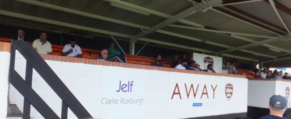 some fans on a bleachers and one with a cap and one has a hat on