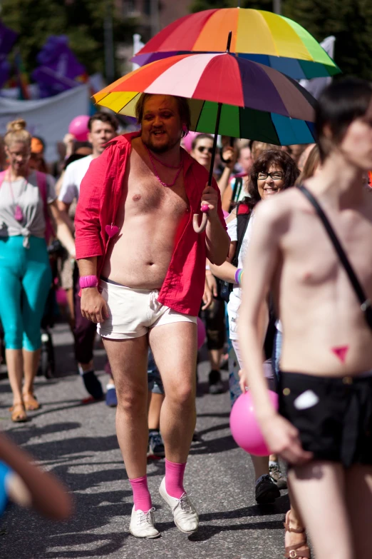 a man wearing shorts and socks, holding an umbrella