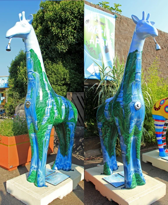 two giraffes on pedestals on display in front of a building