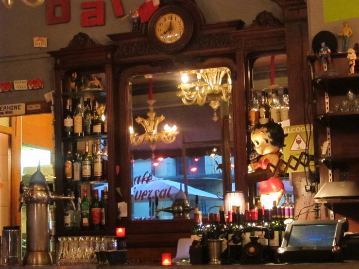 a shelf filled with bottles and lights behind a clock