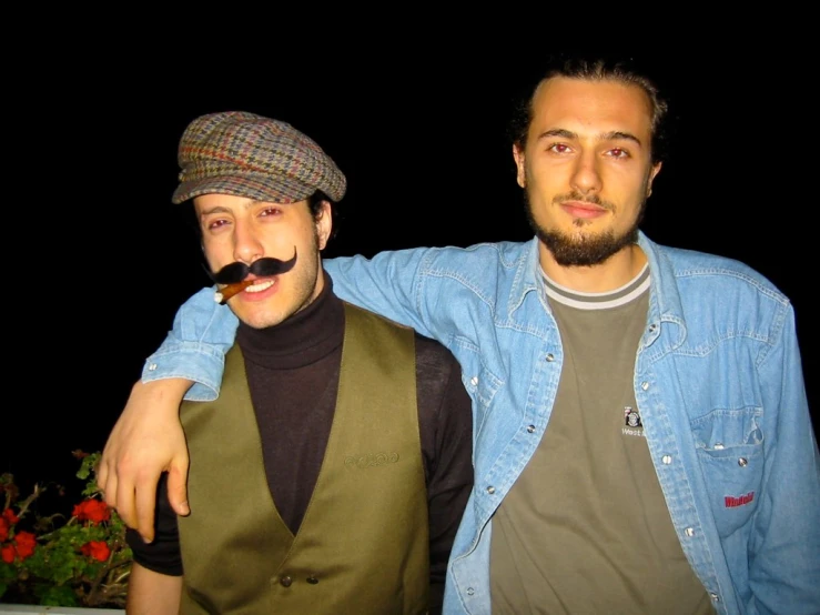 two men standing next to each other with mustaches on their faces